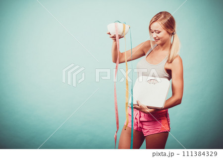 Girl with scales measuring tapes. Weight loss. 111384329