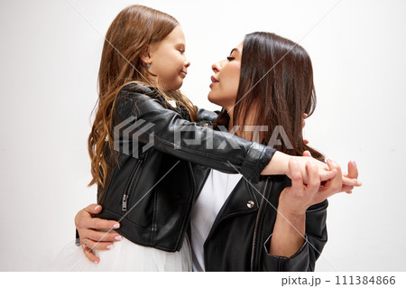 Tender, bonding moment. Happy mother sanding with little daughter, embracing, showing love and care against white studio background 111384866