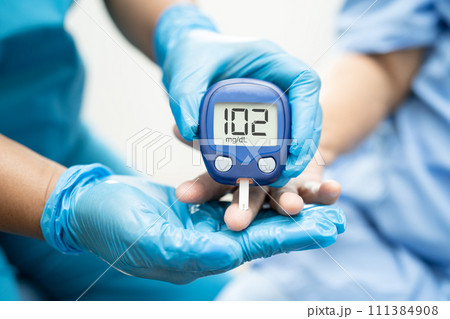 Doctor check diabetes from finger blood sugar level with finger lancet. 111384908