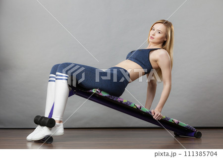 Woman training on bench for sit ups 111385704
