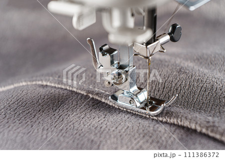 Modern sewing machine with gray velours fabric close up 111386372