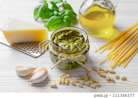Homemade pesto sauce in small jar and ingredients for pasta on white wooden background 111386377