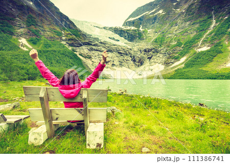 Tourist admiring Boyabreen Glacier in Norway Tourist admiring Boyabreen Glacier in Norway 111386741