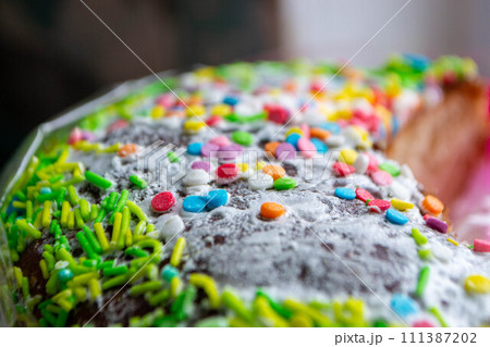 Traditional easter holiday table served with homemade easter cake . A cake with sprinkles on it is decorated with colorful sprinkles. High quality photo 111387202