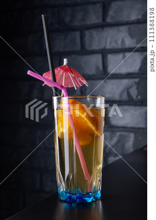 Alcoholic cocktail with orange slices in a blue glass Alcoholic cocktail with orange slices in a blue glass 111388198