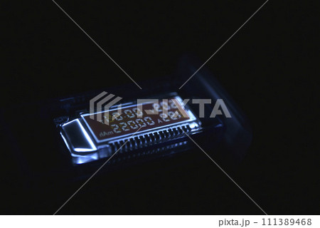 USB measuring device. The electrical meter of the USB devices. The screen of the device in the night. 111389468