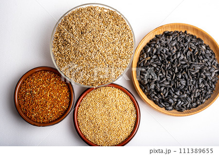 dried grains bird food. Red millet grain, yellow millet grain, black sunflower seeds and canary grass seeds. 111389655