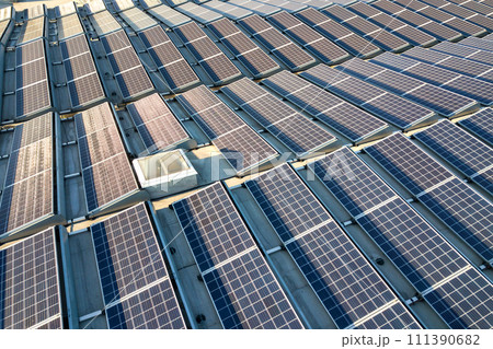 Aerial view of many photo voltaic solar panels mounted of industrial building roof. Aerial view of many photo voltaic solar panels mounted of industrial building roof. 111390682