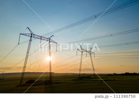 Dark silhouette of high voltage towers with electric power lines at sunrise. Dark silhouette of high voltage towers with electric power lines at sunrise. 111390750