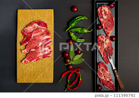 pork meat and vegetables on black background 111390792