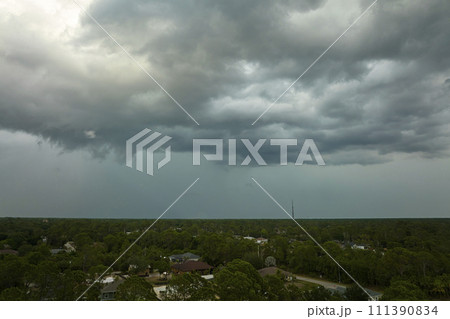 Landscape of dark ominous clouds forming on stormy sky before heavy thunderstorm over rural town area Landscape of dark ominous clouds forming on stormy sky before heavy thunderstorm over rural town area 111390834