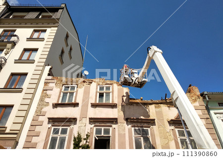 Tower of lift crane and old building under dismantling. 111390860