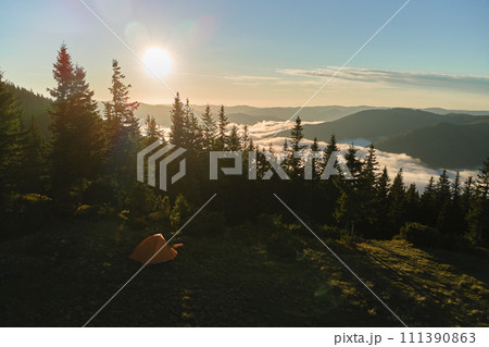 Aerial view of tourist camping tent on mountain campsite at bright sunny evening. Active tourism and hiking concept Aerial view of tourist camping tent on mountain campsite at bright sunny evening. Active tourism and hiking concept 111390863