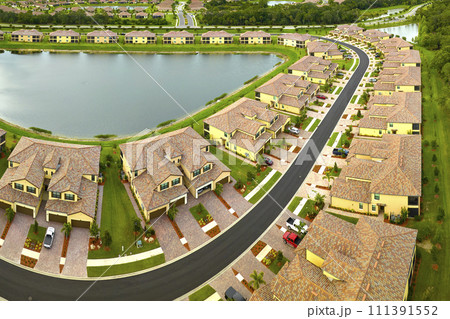 Aerial view of tightly located family houses with retention ponds to prevent flooding in Florida closed suburban area. Real estate development in american suburbs 111391552