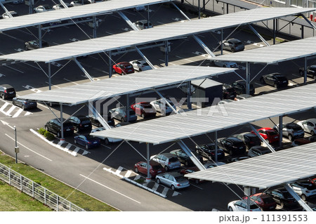 Aerial view of solar panels installed over parking lot with parked cars for effective generation of clean energy 111391553