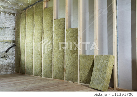 Wooden frame for future walls insulated with rock wool and fiberglass insulation staff for cold barrier. Comfortable warm home, economy, construction and renovation concept. 111391700