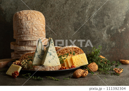 Cheese, bread, walnuts, and thyme on a stone kitchen table. 111392304