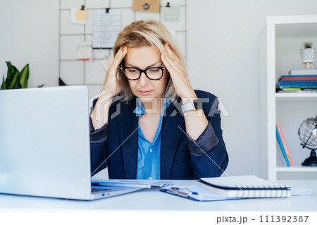 Shocked 50's mature businesswoman, middle-aged experienced female looking at documents in office. Accounting report. Frustrated worried face expression emotion feelings problem perception reaction. Shocked 50's mature businesswoman, middle-aged experienced female looking at documents in office. Accounting report. Frustrated worried face expression emotion feelings problem perception reaction. 111392387