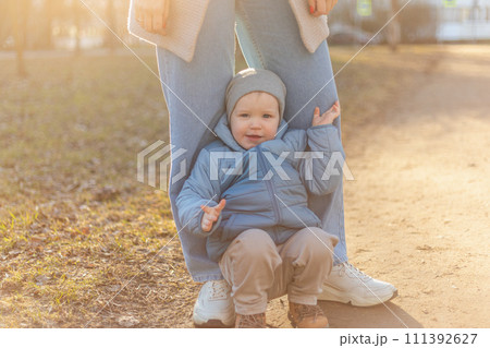 Happy family outdoor. Mother child on walk in park. Mom playing with baby son outdoor. Woman little baby boy resting walking in nature. Little toddler child and babysitter nanny having fun together 111392627