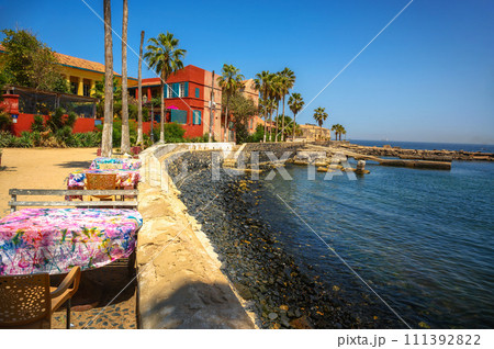 Seaside dining setup with colorful tablecloths on Goree Island, Senegal 111392822