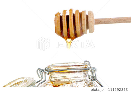 Jar of honey with wooden drizzler 111392858