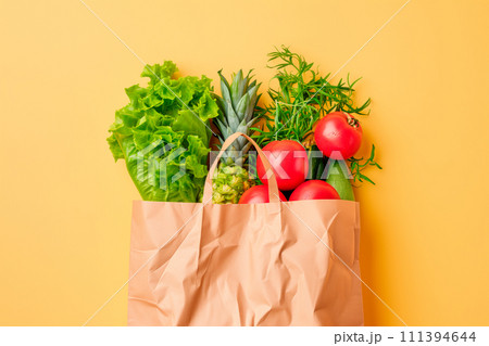 Craft brown shopping paper bag and grocery on blue background. Delivery concept Craft brown shopping paper bag and grocery on blue background. Delivery concept 111394644