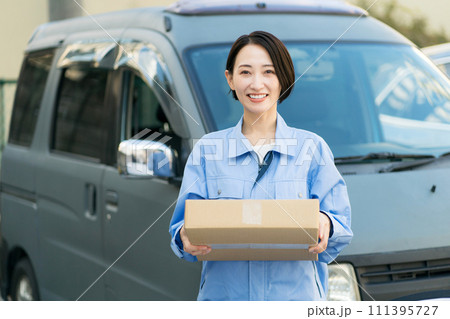 荷物を運ぶ笑顔の若い女性 111395727