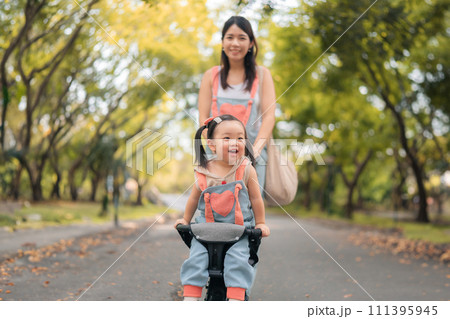 Asian mother walking with daugther in stroller in park,  Happy family concept. 111395945