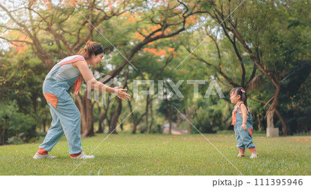 Asian mother walking with daughter in park, Happy family in the park evening light, Happy family concept. Asian mother walking with daughter in park, Happy family in the park evening light, Happy family concept. 111395946