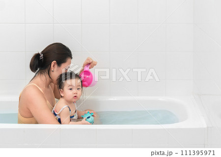 Asian mother and baby girl bathing together in bathtub, Happy lifestyle family concept. Asian mother and baby girl bathing together in bathtub, Happy lifestyle family concept. 111395971