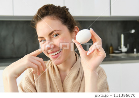Attractive young cheerful girl baking at the kitchen, making dough, holding recipe book, having ideas Attractive young cheerful girl baking at the kitchen, making dough, holding recipe book, having ideas 111396670