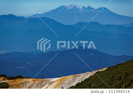 八ヶ岳連峰・硫黄岳稜線から見る赤岩ノ頭の登山者と御嶽 八ヶ岳連峰・硫黄岳稜線から見る赤岩ノ頭の登山者と御嶽 111398519