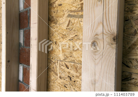 Construction of wood frame walls of a new country house site. Unfinished construction work inside. 111403789