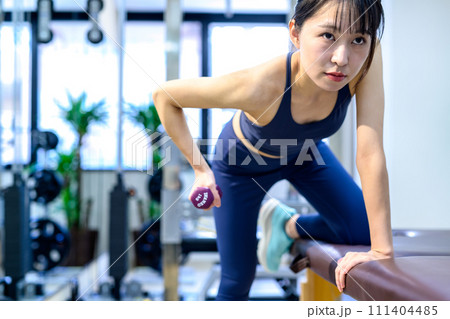 パーソナルジムで体を鍛える若い女性 ワンハンドローイング ダンベルロウ 筋トレ女子 アップ くっきり パーソナルジムで体を鍛える若い女性 ワンハンドローイング ダンベルロウ 筋トレ女子 アップ くっきり 111404485