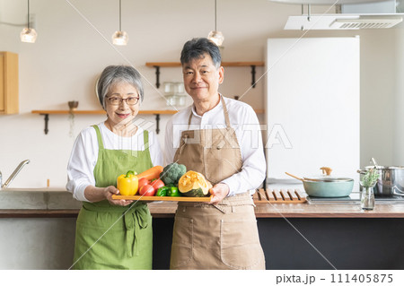 家のキッチンの前で笑顔で野菜をもつアジア人高齢者夫婦(料理教室) 家のキッチンの前で笑顔で野菜をもつアジア人高齢者夫婦(料理教室) 111405875