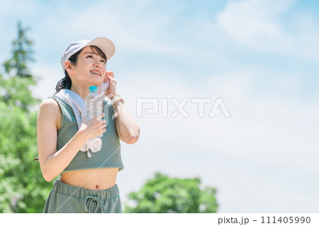 公園で水・ミネラルウォーターを飲む女性(水分補給・運動・ワークアウト・ランニング・ウォーキング) 公園で水・ミネラルウォーターを飲む女性(水分補給・運動・ワークアウト・ランニング・ウォーキング) 111405990