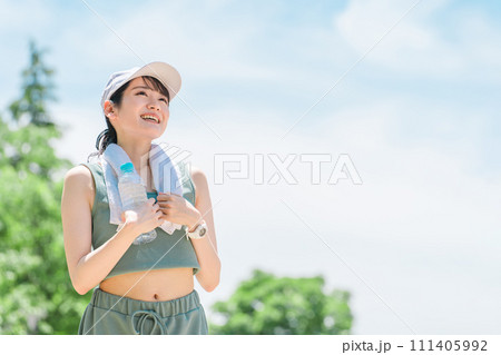 公園で水・ミネラルウォーターを飲む女性(水分補給・運動・ワークアウト・ランニング・ウォーキング) 公園で水・ミネラルウォーターを飲む女性(水分補給・運動・ワークアウト・ランニング・ウォーキング) 111405992