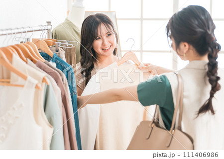 アパレルショップで洋服を買い物・ショッピングする女性とショップ店員 アパレルショップで洋服を買い物・ショッピングする女性とショップ店員 111406986
