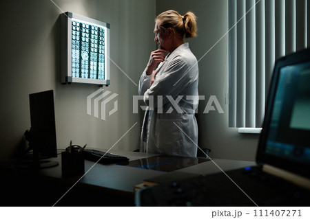 Pensive doctor analyzing brain scan Pensive doctor analyzing brain scan 111407271