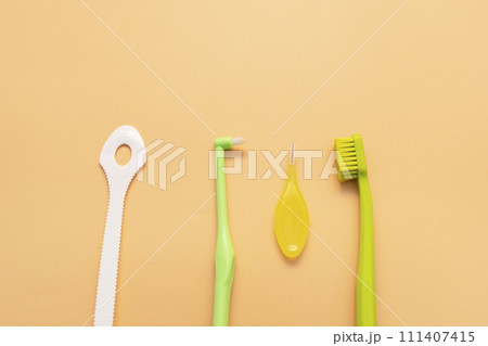 Personal Dental Oral Hygiene Set Kit. Tongue Scraper, Toothbrush, Interdental Toothbrush For Cleaning Between Teeth On Peach Yellow Background. Space For Text. Horizontal Plane Personal Dental Oral Hygiene Set Kit. Tongue Scraper, Toothbrush, Interdental Toothbrush For Cleaning Between Teeth On Peach Yellow Background. Space For Text. Horizontal Plane 111407415