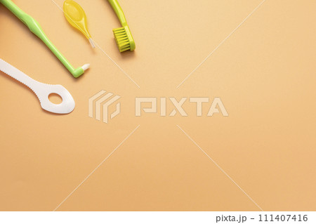 Template Personal Dental Oral Hygiene Kit. White Flexible Tongue Scraper, Toothbrush, Interdental Toothbrush For Cleaning Between Teeth On Peach Yellow Background. Space For Text. Horizontal Plane. Template Personal Dental Oral Hygiene Kit. White Flexible Tongue Scraper, Toothbrush, Interdental Toothbrush For Cleaning Between Teeth On Peach Yellow Background. Space For Text. Horizontal Plane. 111407416