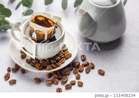 Drip coffee bag with ground coffee in cup Drip coffee bag with ground coffee in cup 111408234