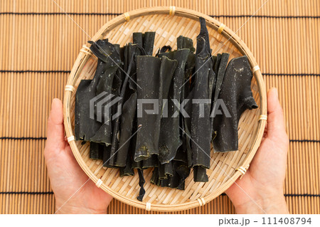 根昆布を持つ女性の手 111408794