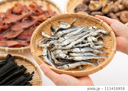 根昆布と煮干しと干し椎茸と厚削りの鰹節を持つ女性の手元 根昆布と煮干しと干し椎茸と厚削りの鰹節を持つ女性の手元 111410958