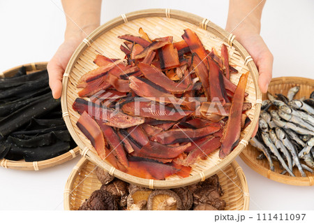 根昆布と煮干しと干し椎茸と厚削りの鰹節を持つ女性の手元 111411097
