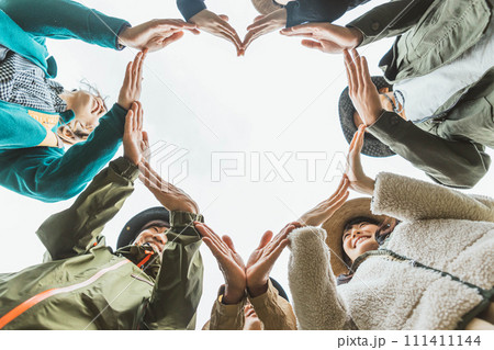 秋冬のキャンプ場で仲間とハートを作る男女（愛情・恋愛・心・寄付・ボランティア） 111411144