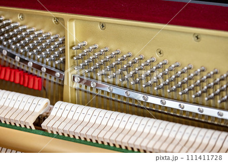 Shallow focus close-up of tools for tuning the internal mechanisms of an upright piano. Gives a feeling of luxury, classic, luxury, grandeur. Pictures can be used on various topics related to music. Shallow focus close-up of tools for tuning the internal mechanisms of an upright piano. Gives a feeling of luxury, classic, luxury, grandeur. Pictures can be used on various topics related to music. 111411728