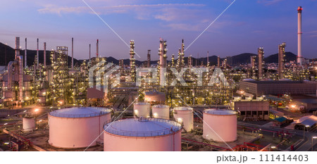 Aerial view oil and gas tank with oil refinery background at night, Glitter lighting of petrochemical plant with night, Manufacturing of petroleum, Products tank in petrochemical plant. Aerial view oil and gas tank with oil refinery background at night, Glitter lighting of petrochemical plant with night, Manufacturing of petroleum, Products tank in petrochemical plant. 111414403