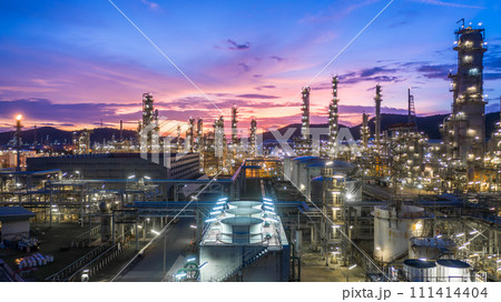 Aerial view oil and gas tank with oil refinery background at night, Glitter lighting of petrochemical plant with night, Manufacturing of petroleum, Products tank in petrochemical plant. Aerial view oil and gas tank with oil refinery background at night, Glitter lighting of petrochemical plant with night, Manufacturing of petroleum, Products tank in petrochemical plant. 111414404