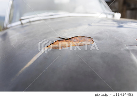 Car paint stripping decay. Peeling paint and rusted metal on an old timer vehicle Car paint stripping decay. Peeling paint and rusted metal on an old timer vehicle 111414482